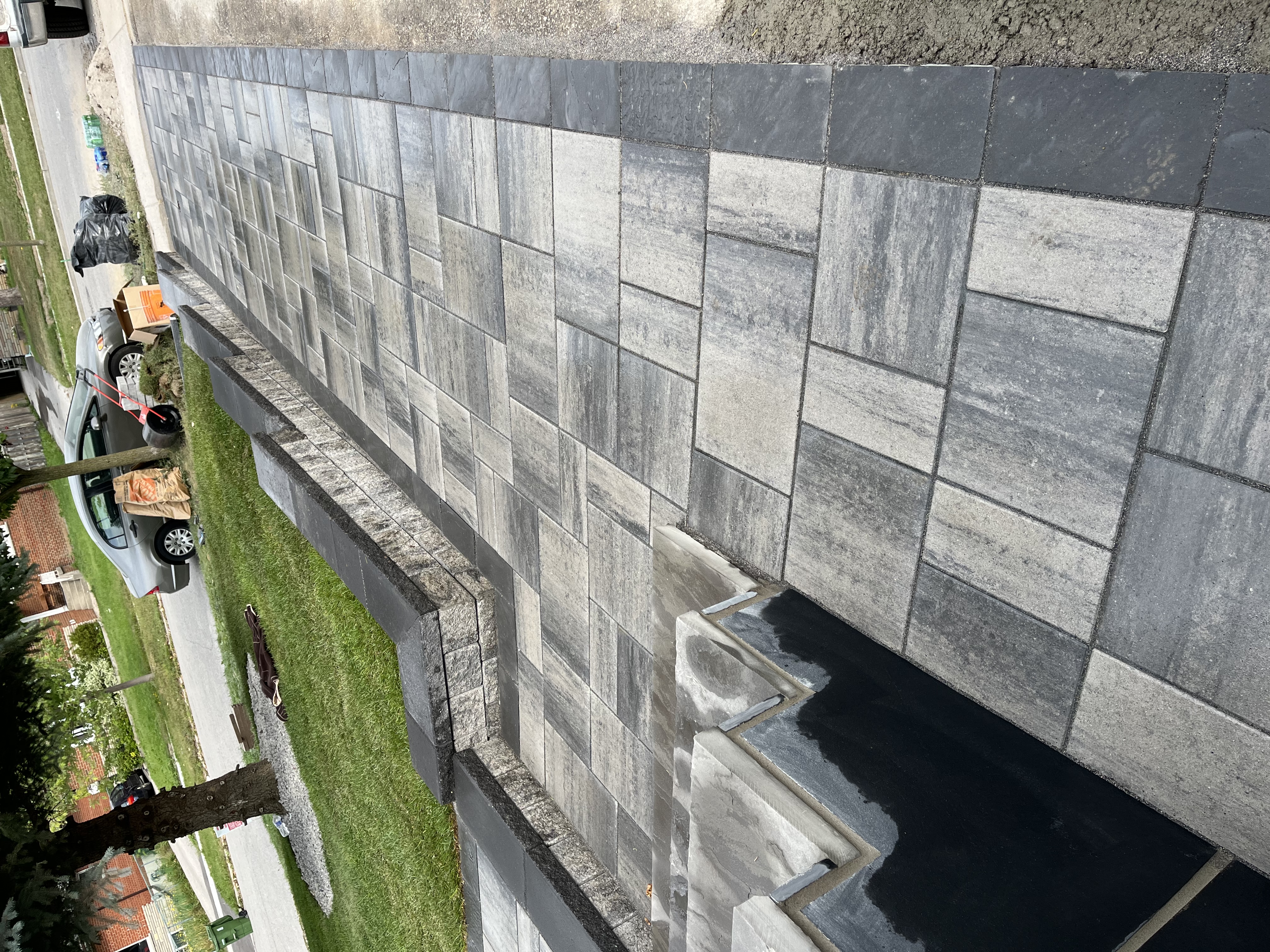 Completed retaining wall project with capped wall lines and controlled elevation change