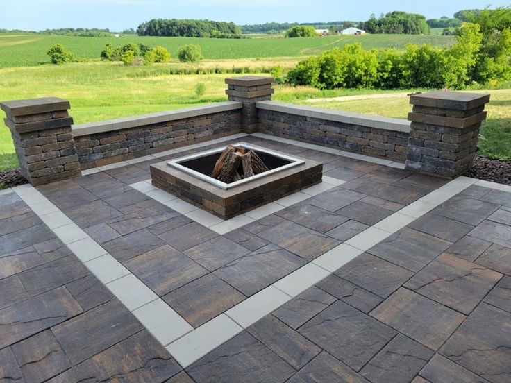 Stone water feature with warm landscape lighting at dusk on a paver patio